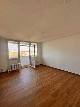 Wohnzimmer mit weißen Wänden, Design-Vinylboden in Holzoptik und Zugang zum Balkon..jpg - 