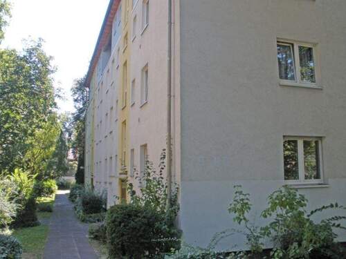Seitliche Ansicht der Wohngebäude mit Weg zu den Hauseingängen und Grünanlage - 2 Zimmer Etagenwohnung in Darmstadt