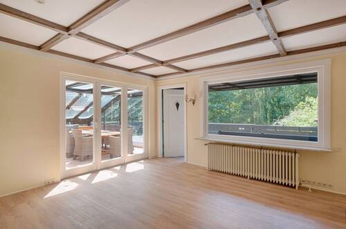 Helles Wohnzimmer mit Zugang zum Wintergarten und Terrasse - 