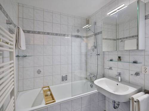 Hell gefliestes Bad mit Duschwanne und Waschmaschinenanschluss - Lichtdurchflutete und unvermietete Wohnung mit 2 Balkonen