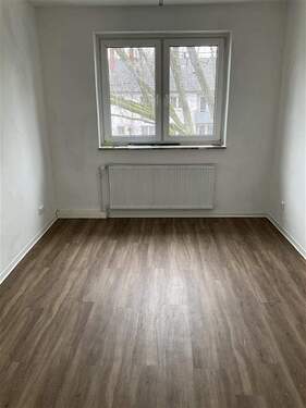 Zimmer mit Fenster und Fußboden in Holzoptik - 