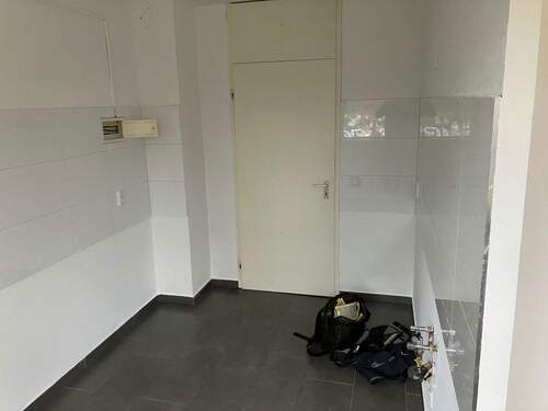 Weißgestrichene Küche mit weißen Spiegelfließen an der Wand und schwarzen Fliesenboden - 3 Zimmer Etagenwohnung zur Miete in Mannheim