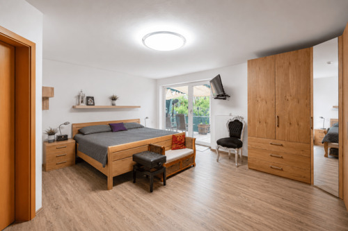 Schlafzimmer im Souterrain mit Zugang zur überdachten Terrasse - 