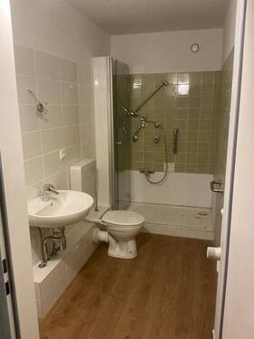 Badezimmer mit neuem Bodenbelag in Holzoptik, Wandfliesen in weiß und grün, Dusche, barrierearm - Etagenwohnung mit 43,40 m&sup2; in Wiesbaden zur Miete