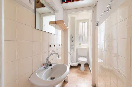 Sanitärbereich mit Waschbecken, WC und Tageslichtfenster - 