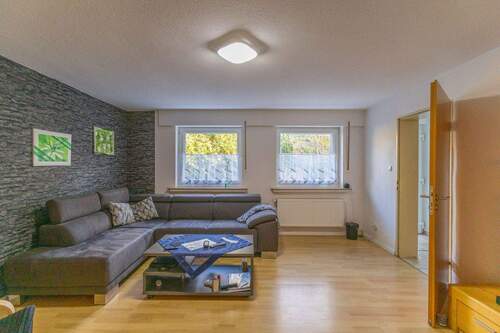 Wohnzimmer mit halb offener Küche und Tresen - 