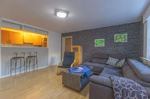 Wohnzimmer mit halb offener Küche und Tresen - 