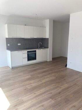 Einbauküche mit weißen Fronten und dunkler Rückwand im Wohnzimmer integriert - Etagenwohnung mit 34,00 m&sup2; in Mannheim zur Miete