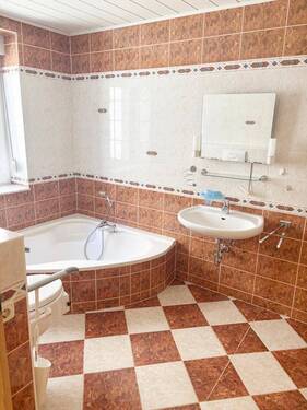 Wannenbadezimmer mit Fenster, Dusche und behindertengerechter Toilette - 