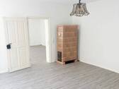 Schlafzimmer mit Kachelofen und Blick Richtung Wohnzimmer - 