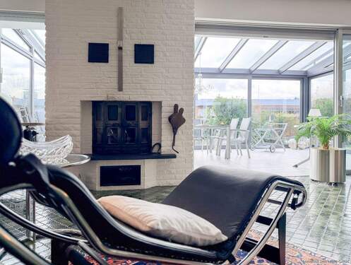 Wohnbereich mit Kamin und Blick in den großzügigen Wintergarten - 5 Zimmer Bungalow zum Kaufen in Hamm