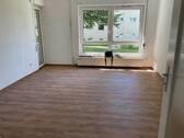 Blick in das Wohnzimmer mit Boden in Holzoptik und Zugang zum Balkon.jpg - Schöne 3-Zimmer Erdgeschosswohnung mit neuen Bodenbelägen und Balkon zu vermieten