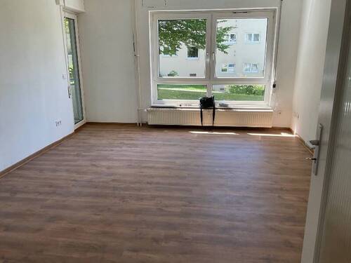Blick in das Wohnzimmer mit Boden in Holzoptik und Zugang zum Balkon.jpg - Schöne 3-Zimmer Erdgeschosswohnung mit neuen Bodenbelägen und Balkon zu vermieten