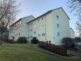 Blick auf das Mehrfamilienhaus mit Grünflächen im Vordergrund - 