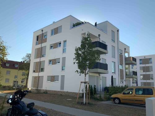 Seitliche Ansicht des viergeschossigen Wohngebäudes - Moderne 3-Zimmer-Wohnung im Neubaugebiet