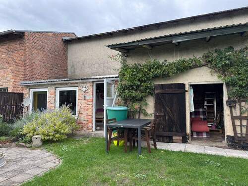 Blick auf Wirtschaftsgebäude, links Gartenlaube - 