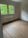 Schlafzimmer mit großem Fenster. Weißer Decke, tapezierfähigen Wänden und braunem Vinylboden..JPG - 