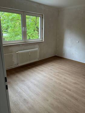 Schlafzimmer mit großem Fenster. Weißer Decke, tapezierfähigen Wänden und braunem Vinylboden..JPG - 
