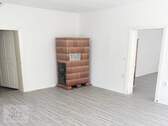 Wohnzimmer mit Kachelofen und Blick Richtung Schlafzimmer - 2 Zimmer Etagenwohnung zur Miete in Mühlberg