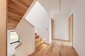 Das gemauerte Treppenhaus mit Stufenspots, Holzhandlauf und Deckenverkleidung sorgt für eine wohlige Atmosphäre - 