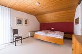 Das Elternschlafzimmer überzeugt durch einen Einbauschrank und den angrenzenden Balkon. - 