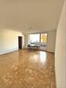 Wohnzimmer mit Parkettfußboden und Zugang zum großen Balkon - 3 Zimmer Etagenwohnung in Uelzen