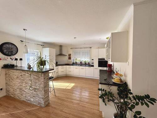 Blick in die offene Küche mit einer Tresenabtrennung zum Esszimmer - 