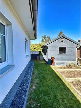 Ostseite des Bungalows mit Blick auf das Gartenhaus und die Gemüsebeete - 
