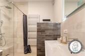 Badezimmer mit bodengleicher Dusche und stilvoller Ausstattung - 
