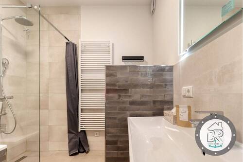 Badezimmer mit bodengleicher Dusche und stilvoller Ausstattung - 