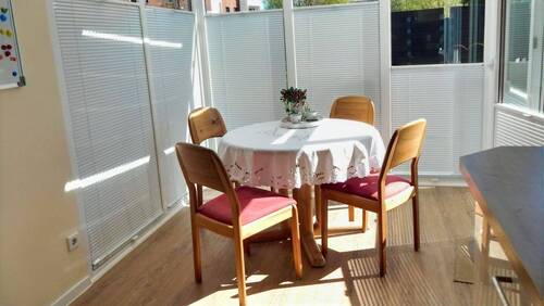 gemütlicher Wintergarten mit Blick und Ausgang auf die Terrasse - 