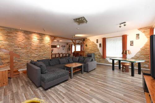 offener Wohn- und Essbereich mit dekorativen Steinwänden - 