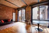 Wohnzimmer mit Zutritt auf den Balkon - Möbliertes Wohnen in der Knopffabrik - Industrial Charme mit Balkon im Szeneviertel