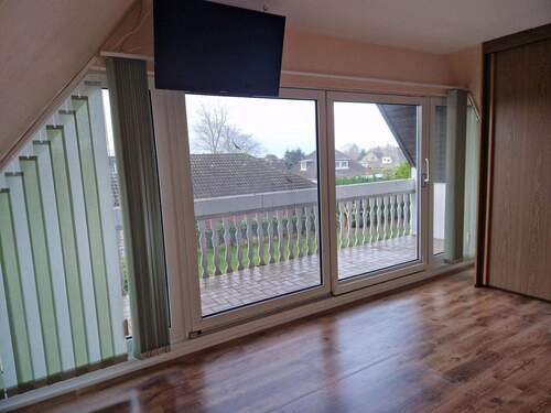 Zimmer mit großer Fensterfront und Zugang zum Balkon - 