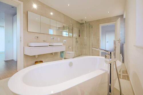 Badezimmer mit freistehender Badewanne und großer Dusche - 