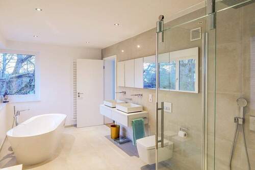 Badezimmer mit freistehender Badewanne und großer Dusche - 