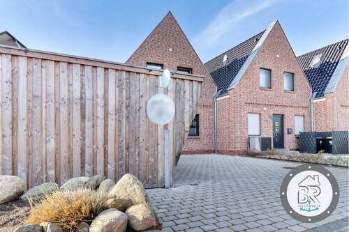 Ansprechende Hausansicht mit Friesenwall und Carportbereich - Etagenwohnung mit 69,00 m&sup2; in Fehmarn zum Kaufen