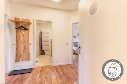 Einladender Eingangsbereich mit Garderobe und warmem Bodenbelag - 