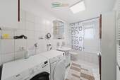 Helles Badezimmer mit Badewanne und Fenster - 