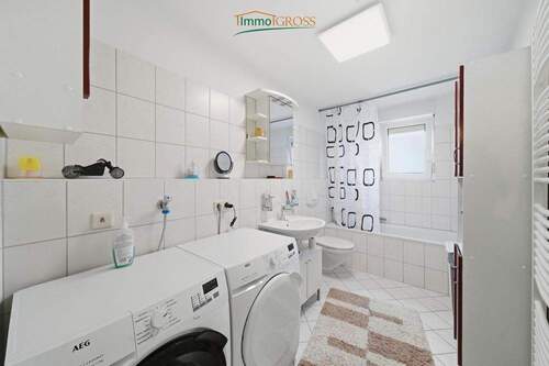 Helles Badezimmer mit Badewanne und Fenster - 