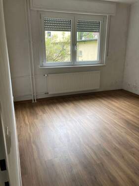 - Beispielbild: Schlafzimmer mit PVC-Bodenbelag in Holzoptik mit tapezierten Wänden. - 