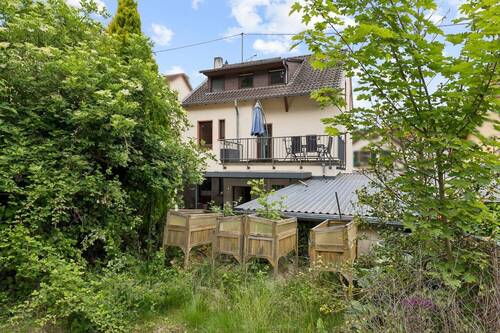 Rückansicht des Hauses mit Balkon und Gartenbereich - 
