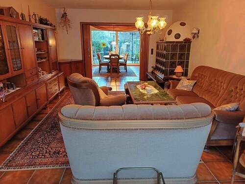 Wohn-Esszimmer mit Kachelofen und Ausgang Freisitz - 