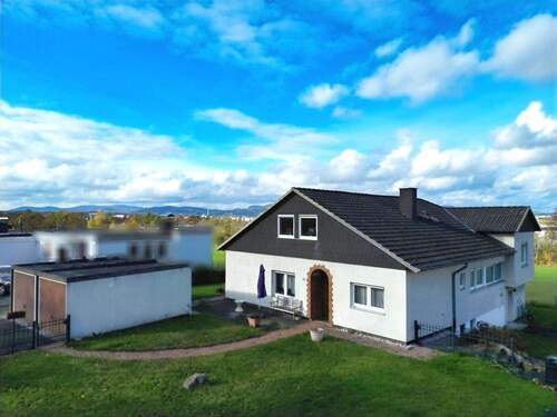 Frontansicht mit Vorgarten und Doppelgarage - Feldrandlage und Top-Anbindung garantiert: Sanierungsbedürftiges Einfamilienhaus in Lohfelden