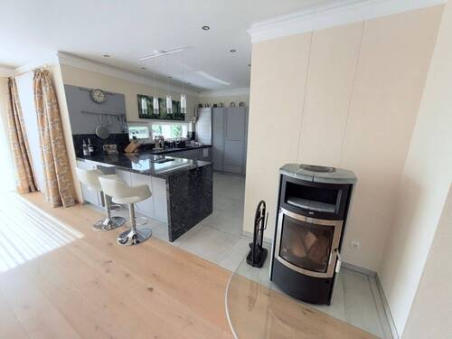 Wohnzimmer mit Küchenansicht und Kaminecke - 