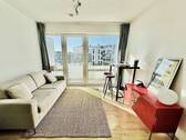 Wohnzimmer mit großer Fensterfront - Sonnige 1-Zimmer-Wohnung mit großen Balkon am Winterhuder Marktplatz