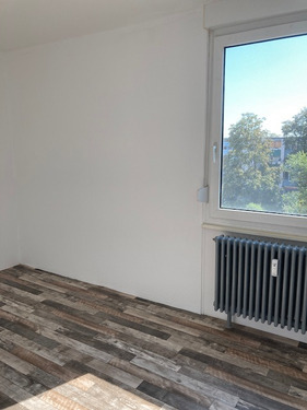 Weißgestrichenes Schlafzimmer mit dunkelbraunen misch Parkett sowie einem kleinen Doppelfenster. - 3 Zimmer Etagenwohnung zur Miete in Mannheim