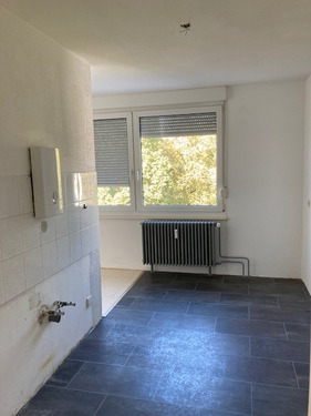 Weißgestrichene Küche mit weißen Spiegelfliesen an der Wand und schwarzem Fliesenboden als auch einem Doppelfenster - Etagenwohnung mit 77,00 m&sup2; in Mannheim zur Miete