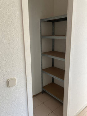 Weißgestrichene Abstellkammer mit beigem Fliesenboden - 