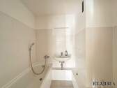 Badezimmer mit Badewanne und Waschmaschinenanschluss - 